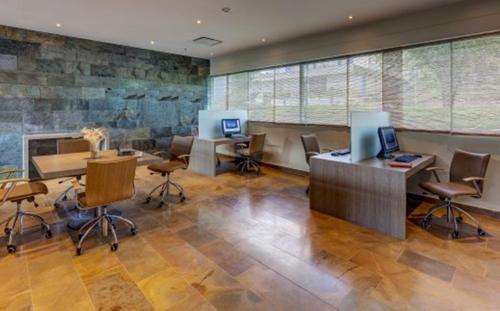 an office with desks and chairs and two computers at Estelar Villavicencio Hotel & Centro De Convenciones in Villavicencio