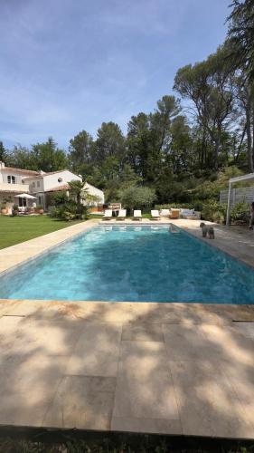 une grande piscine bleue dans une cour dans l'établissement Belle Villa climatisée calme dans un domaine privé, à Peynier