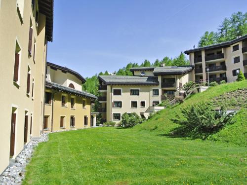a row of buildings on a hill with a green yard at Apartment Residenza Chesa Margun 57-4 by Interhome in Surlej