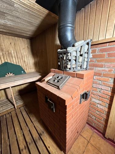 a brick stove in a room with a bench at Trijų žvaigždučių palapinė Vilniuje in Vilnius
