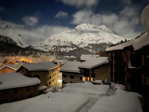 a city covered in snow with a mountain in the background at Apartment Residenza Chesa Margun 57-4 by Interhome in Surlej