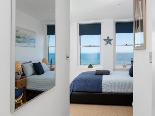 a bedroom with two beds and a mirror at 1 Little Beach in Woolacombe