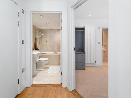 a white bathroom with a toilet and a sink at 1 Little Beach in Woolacombe