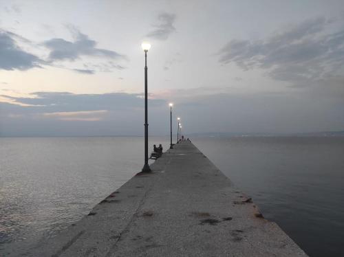 a pier with street lights on the water at Happy Home in Agia Triada