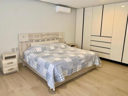 a bedroom with a bed and a dresser and cabinets at Ocean View Condo in Mazatlán