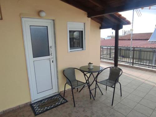 a patio with a table and chairs on a balcony at Happy Home in Agia Triada