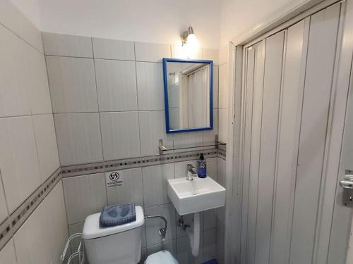 a bathroom with a toilet and a sink and a mirror at Happy Home in Agia Triada