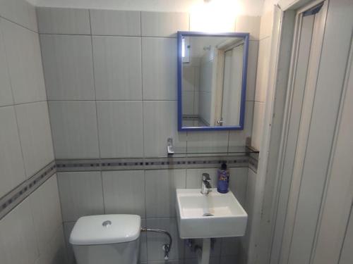 a white bathroom with a sink and a mirror at Happy Home in Agia Triada