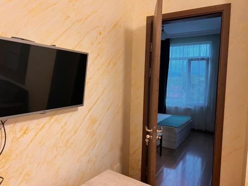 a flat screen tv on the wall of a room at Apartments NITA in Batumi