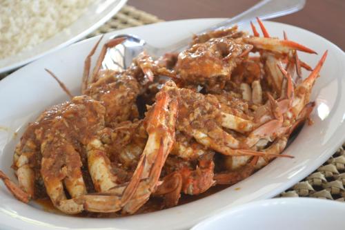 a plate of food with shrimp in a sauce at Wellé Wadiya Beach Villa in Kalpitiya