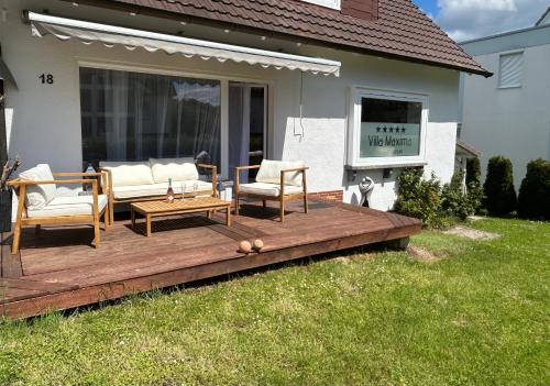 a wooden deck with two chairs and a table at Villa Maxima mit Klimaanlage in Bad Wildungen