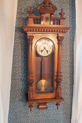 a wooden grandfather clock hanging on a wall at Holiday Home Itzendorfer Rott-2 by Interhome in Norddeich