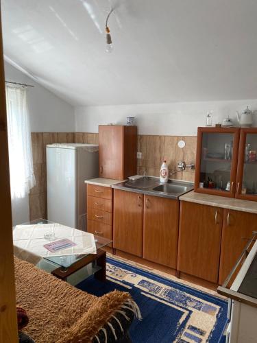 eine Küche mit Holzschränken und einem Kühlschrank in der Unterkunft Seosko domaćinstvo Miko Merdović in Berane