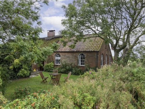 a brick house with a table and chairs in the yard at Holiday Home Itzendorfer Rott-2 by Interhome in Norddeich