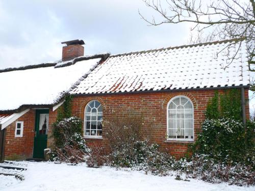 a red brick house with snow on the roof at Holiday Home Itzendorfer Rott-2 by Interhome in Norddeich