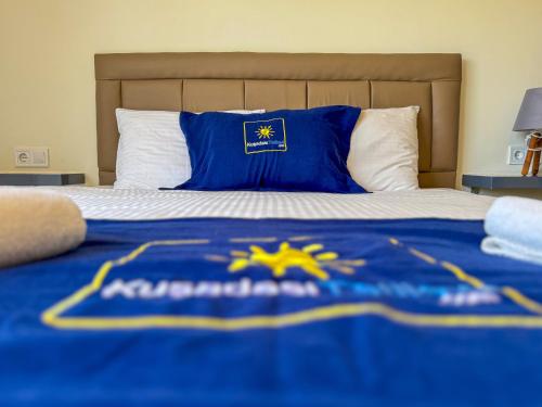 a bed with a blue and yellow blanket on it at Exclusive Villas in Kusadası