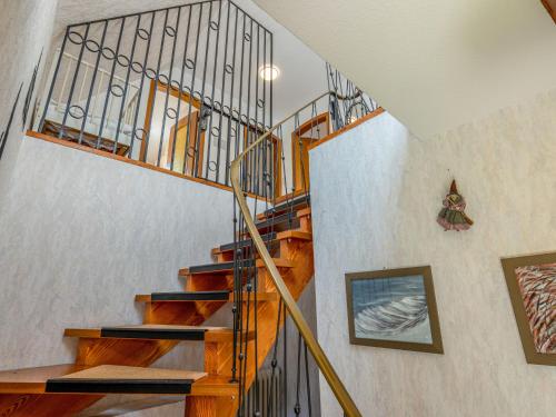 a wooden staircase with a metal railing in a house at Apartment Wichtelmännchen by Interhome in Dittishausen