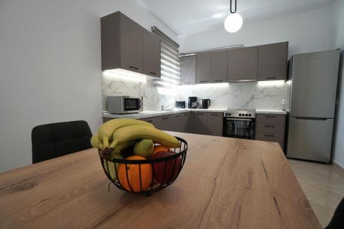 a bowl of fruit on a wooden table in a kitchen at Anna's Apartments in Kremasti