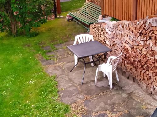 a table and two chairs and a bench in a yard at Chalupa Na Polní in Jemnice