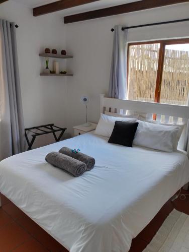 a bedroom with a white bed with two towels on it at Villa Wal Farmstay in Hartebeest Rivier