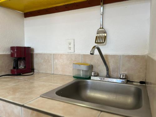 a kitchen sink with a spatula hanging over it at INMOTEGA - Suites TG in San Luis Potosí
