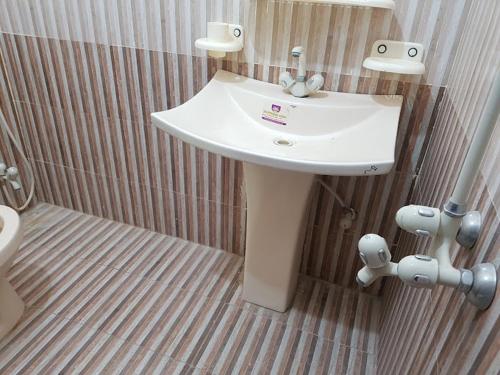 a bathroom with a white sink and a toilet at Aimys Villa Guest House in Multan