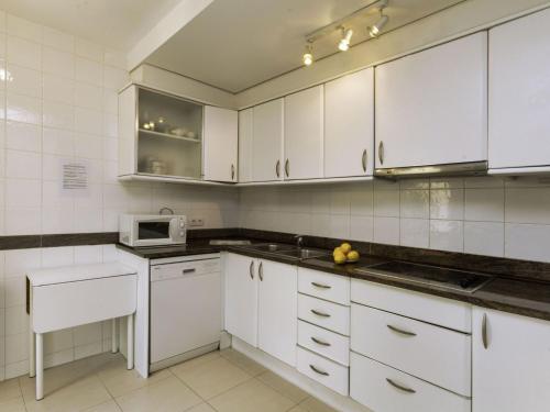 a kitchen with white cabinets and a microwave at Holiday Home Mar Nou by Interhome in Llança