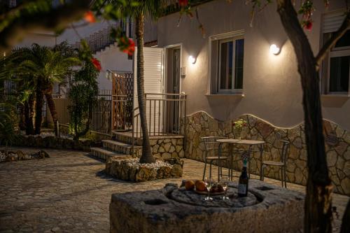 a building with a table and a bottle of wine at Elima la Casuzza in Alcamo
