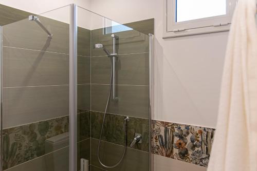 a shower with a glass door in a bathroom at Elima la Casuzza in Alcamo