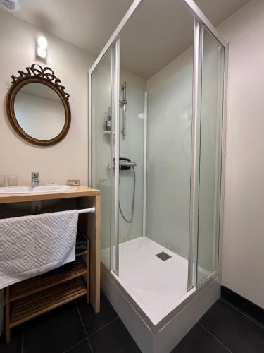 une douche dans une salle de bain avec un lavabo et un miroir dans l'établissement l'Aod, maison d'hôtes insulaire, à Lampaul