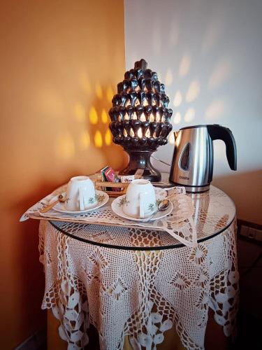 a table with a tea kettle and cups on it at Villa Hirschen in Zafferana Etnea