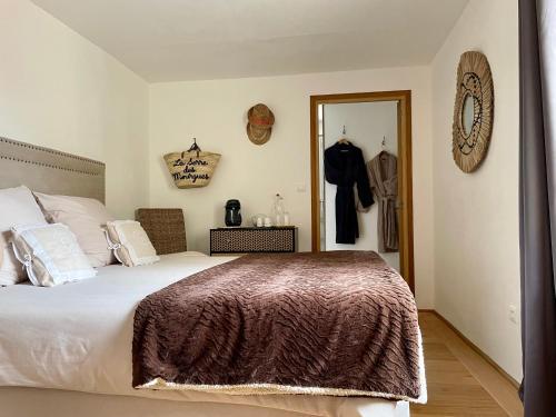- une chambre avec un grand lit et un miroir dans l'établissement La Serre Des Mourgues, à Méjannes-lès-Alès