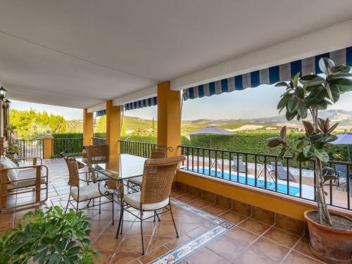 einen Balkon mit einem Tisch und Stühlen sowie Poolblick in der Unterkunft Holiday Home Villa San Vicente by Interhome in Baena