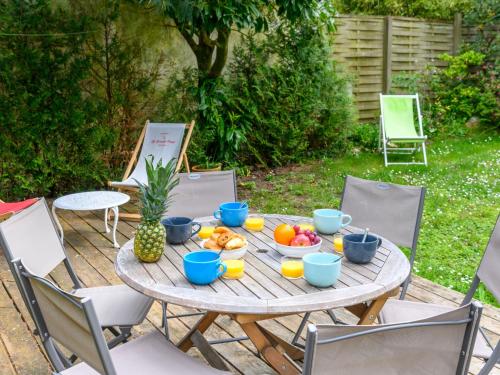 une table en bois avec des bols de fruits dans l'établissement Holiday Home L'Oustalet by Interhome, à Carnac