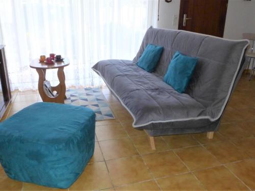 - un canapé avec des oreillers bleus dans le salon dans l'établissement Holiday Home Bosquet aux Ecureuils by Interhome, à Capbreton