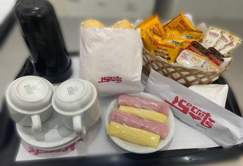 Una bandeja de comida con pasteles y una cesta de aperitivos. en Motel Secrets 3, en São Paulo