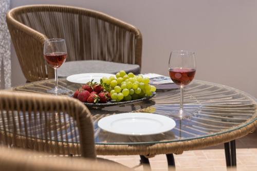 a table with two glasses of wine and a bowl of fruit at Pergola in Pollonia