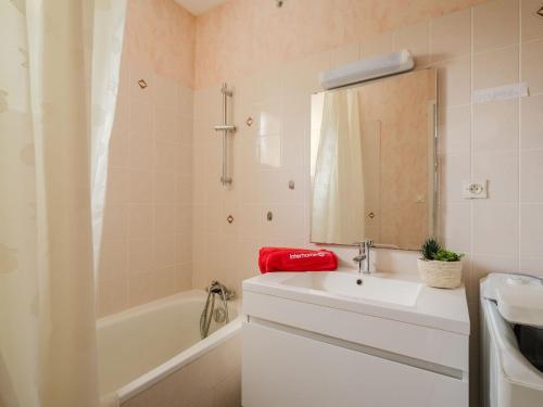 une salle de bain avec un lavabo, une baignoire et un miroir dans l'établissement Holiday Home La Villa Marie by Interhome, à Dinard