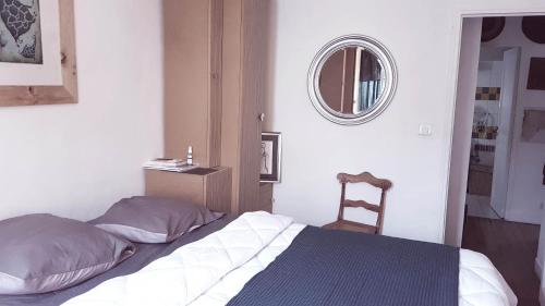 une chambre avec un lit, un miroir et une chaise dans l'établissement Le 122 aux Batignolles, à Paris