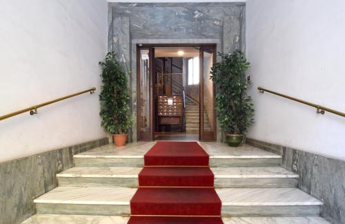 un conjunto de escaleras con alfombra roja y plantas en B&B Casa Cimabue Roma, en Roma