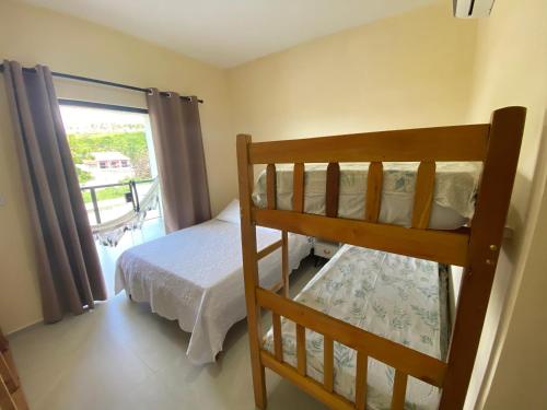 a bedroom with a bunk bed and a balcony at CASA BRISA MAR DELUXE - Maragogi in Maragogi