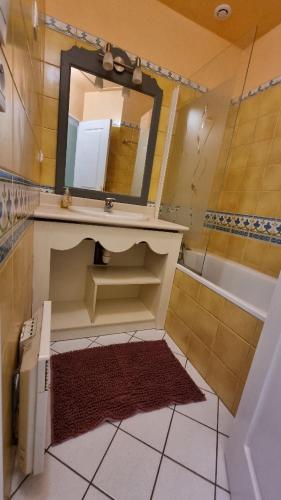 une salle de bain avec un lavabo et un miroir dans l'établissement Cottage paisible au coeur du golf saint Laurent , linge de maison et ménage inclus, à Ploemel