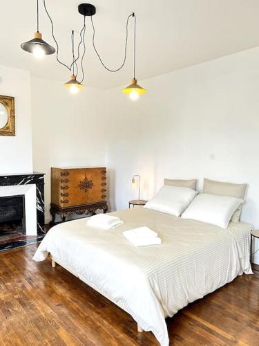 - une chambre avec un grand lit blanc et une cheminée dans l'établissement Villa Eden - 9 pers, à Charleville-Mézières