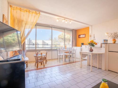 eine Küche und ein Esszimmer mit einem Tisch und Stühlen in der Unterkunft Apartment Le Florid-3 by Interhome in Cap d'Agde