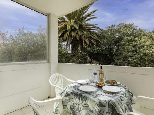 une table et des chaises sur un balcon avec un palmier dans l'établissement Apartment Super Plage-2 by Interhome, à Saint-Cyr-sur-Mer