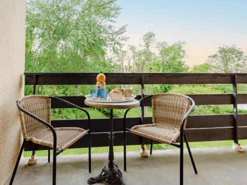 - une table et deux chaises sur une terrasse couverte dans l'établissement Apartment Le Sporting-16 by Interhome, à Cabourg