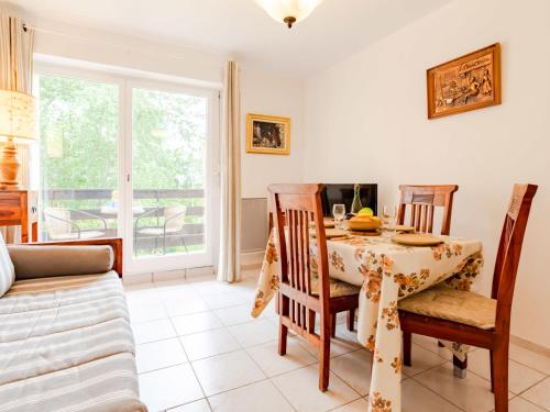 une salle à manger avec une table, des chaises et un canapé dans l'établissement Apartment Le Sporting-16 by Interhome, à Cabourg