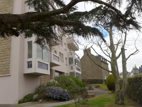 un bâtiment blanc avec un arbre devant lui dans l'établissement Apartment Saint Michel by Interhome, à Saint-Malo