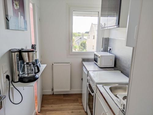 une petite cuisine avec un évier et un micro-ondes dans l'établissement Apartment Saint Michel by Interhome, à Saint-Malo