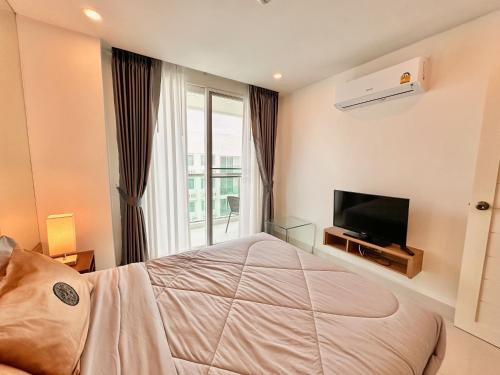 En eller flere senge i et værelse på CORNER 1 Bedroom Condo in Amazon Residence